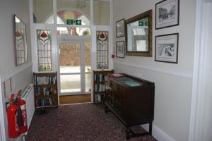 a hallway with a room with a book shelf and windows at Broadshade Holiday Apartments in Paignton