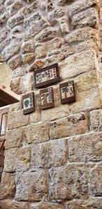 a stone wall with four pictures on it at 19th Century Magical House in Galilee in ‘Eilabūn