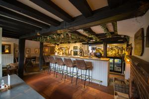 un bar con una fila de taburetes en una habitación en The Bull Inn Pub en Stanford Dingley