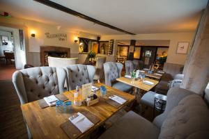 ein Esszimmer mit einem Tisch und Sofas in der Unterkunft The Bull Inn Pub in Stanford Dingley