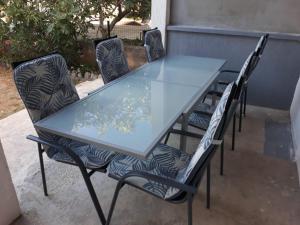 a glass table and chairs on a patio at Apartments Jurlina in Seline