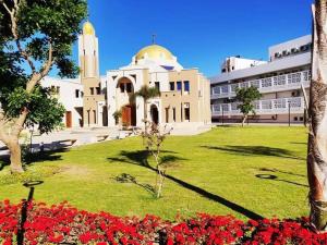 a building with a field of flowers in front of it at Nice view in ‘Izbat Abū Sulayman