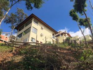 a house on a hill with a fence at Pousada Aromas da Pedra in Pedra Azul