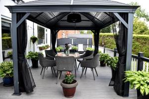 une pergola noire avec une table et des chaises sur une terrasse dans l'établissement Maryland, à Derby