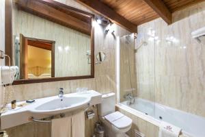 a bathroom with a sink, toilet and bathtub at Hotel Sao Joao De Deus by RIDAN Hotels in Elvas
