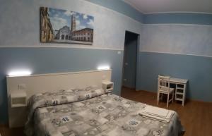 Schlafzimmer mit einem Bett, einem Tisch und einem Schreibtisch in der Unterkunft Affittacamere Rossi in Lucca