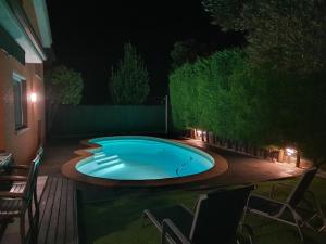 a swimming pool at night with chairs around it at Nice Home in Borgoñá