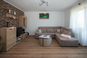 ein Wohnzimmer mit Couch und Fernseher in der Unterkunft Apartman Lucija & Luka in Otočac
