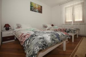 ein Schlafzimmer mit zwei Betten und einem Tisch und einem Fenster in der Unterkunft Apartman Lucija & Luka in Otočac