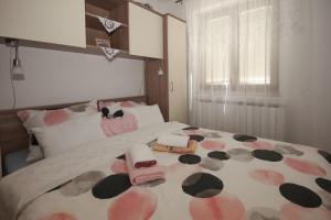ein Schlafzimmer mit einem Bett mit rosa und braunen Blumen darauf in der Unterkunft Apartman Lucija & Luka in Otočac