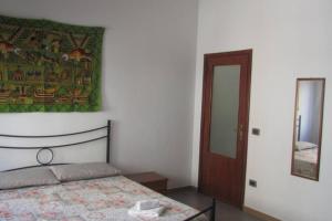 a bedroom with a bed and a painting on the wall at APPARTAMENTO CAGLIARI in Cagliari