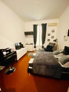 a bedroom with a bed and a living room at Chambres dans guest house Centre ville in Menton