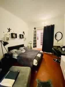 マントンにあるChambres dans guest house Centre villeのベッドルーム1室(ベッド2台、ソファ付)