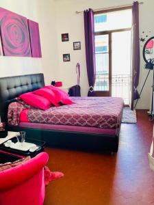 a bedroom with a bed with red pillows on it at Chambres dans guest house Centre ville in Menton