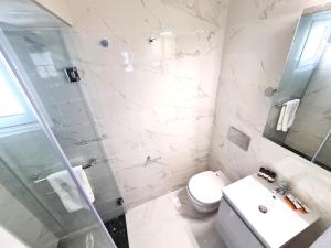 une salle de bains blanche avec toilettes et lavabo dans l'établissement Monte Smith City Home, à Rhodes