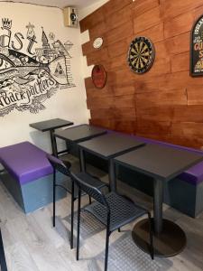 uma sala de jantar com mesas e cadeiras e um alvo de dardos na parede em Lagan Backpackers em Belfast