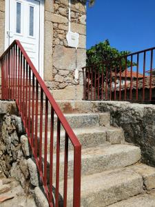 a set of stairs in front of a house with a red railing at The Maggie Farm in Aranhas