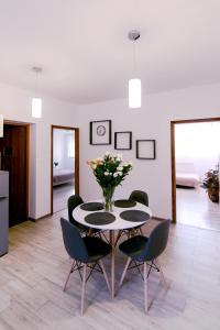 a dining room with a table with chairs and a vase of flowers at Apartament u Andrzeja in Polanica-Zdrój