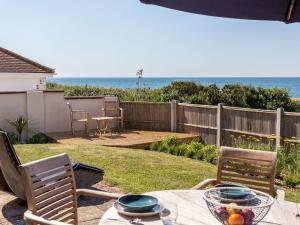 un patio con mesa, sillas y el océano en Beach Haven, en Dorchester