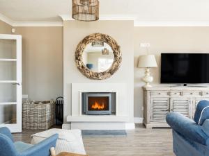 a living room with a fireplace and a mirror at Beach Haven in Dorchester