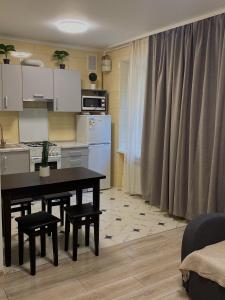 cocina con mesa y sillas en una habitación en Затишні апартаменти подобово,центр, en Ternopilʼ