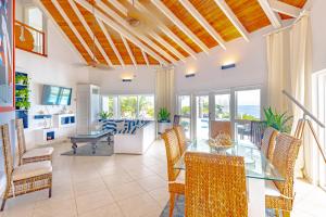 a dining room with a glass table and chairs at Villa Northwinds - At Orange Hill - Private Pool in Nassau