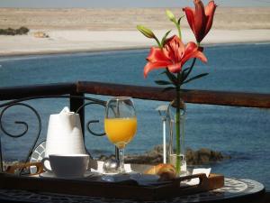 巴伊亚英格莱萨Hotel K的一张桌子,上面放着花瓶和一杯橙汁