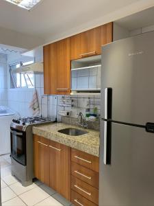a kitchen with a stainless steel refrigerator and a sink at Natal Verano Ponta Negra in Natal