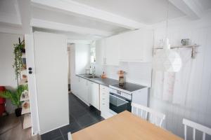 eine kleine Küche mit weißen Schränken und einem Tisch in der Unterkunft Two Bedroom Vacation Home in the Center of Tórshavn in Tórshavn
