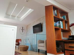 a living room with a book shelf and a tv at Augusta Boutique House in Lisbon