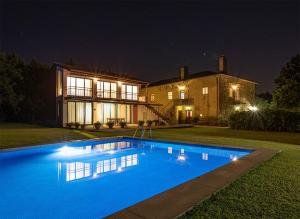 a large swimming pool in front of a house at night at Quinta do Casal de S. Miguel de Soutelo in Vila Verde