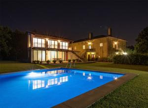 ein großer Pool vor einem Haus in der Nacht in der Unterkunft Quinta do Casal de S. Miguel de Soutelo in Vila Verde