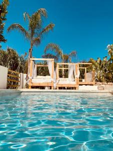 アラウリン・エル・グランデにあるFinca Mil Estrellasの白い椅子2脚が備わるリゾートのプールを利用できます。