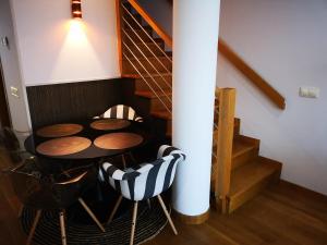 Una mesa y sillas en una habitación con escalera. en Golden Vedra Residences, en Pontevedra