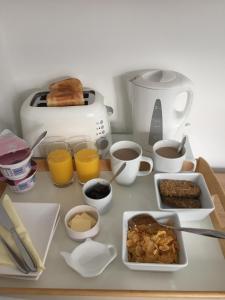 a table topped with breakfast foods and a toaster at Basingstoke En Suite Room in Garden Annex in Basingstoke
