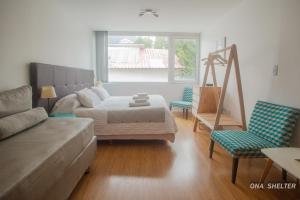 uma sala de estar com uma cama e um sofá em Ona Shelter em Ushuaia