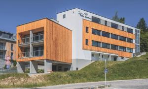 a building on top of a hill next to a street at Apartman Central Ski & Bike in Janske Lazne