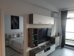 a bedroom with a bed and a flat screen tv at PANORAMIS PROMENADA-LARISA in Mamaia Sat/Năvodari