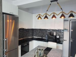 a kitchen with white cabinets and a counter top at PANORAMIS PROMENADA-LARISA in Mamaia Sat/Năvodari