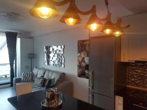 a living room with a couch and a kitchen with lights at PANORAMIS PROMENADA-LARISA in Mamaia Sat/Năvodari +20 photos
