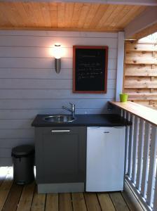 a kitchen with a sink and a chalkboard on a porch at Bulle d'R in Dournazac