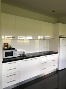 a kitchen with white cabinets and a sink and a microwave at The Glen in Raleigh