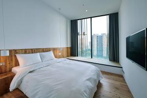 台中市にあるStar Hostel Taichung Parklaneのベッドルーム(白いベッド1台、大きな窓付)
