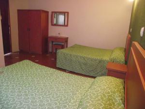 a hotel room with two beds and a cabinet at HOTEL POSADA SANTIAGO in Xalapa