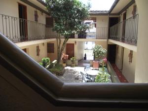 un patio interior de un edificio con mesa y sillas en HOTEL POSADA SANTIAGO en Xalapa