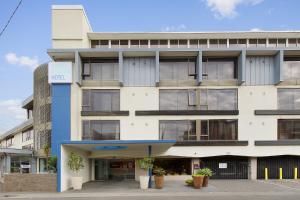 un gran edificio blanco con ventanas y plantas en Cosmopolitan Hotel Melbourne, en Melbourne