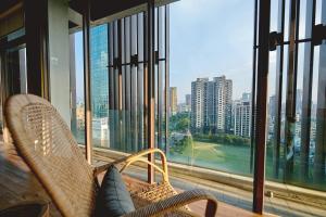a balcony with two chairs and a view of a city at Star Hostel Taichung Parklane in Taichung