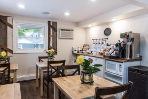 Kittery Inn & Suites في كيتري: مطبخ وغرفة طعام مع طاولات وكراسي خشبية