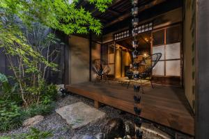a house with two chairs and a wooden bench at Kishoan in Kyoto