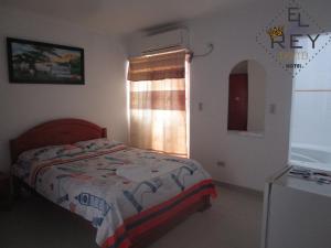 a bedroom with a bed and a window at Hotel Rey David in Yopal